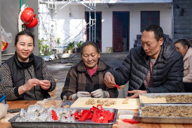 王樹(shù)艷一家正在包核桃糖.jpg