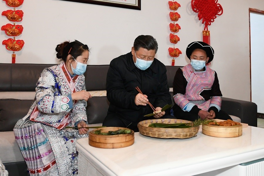 2021年2月3日下午，習(xí)近平在貴州畢節(jié)市黔西縣新仁苗族鄉(xiāng)化屋村苗族村民趙玉學(xué)家，同一家人邊聊家常邊制作當(dāng)?shù)貍鹘y(tǒng)節(jié)日食品黃粑。新華社記者 李學(xué)仁 攝