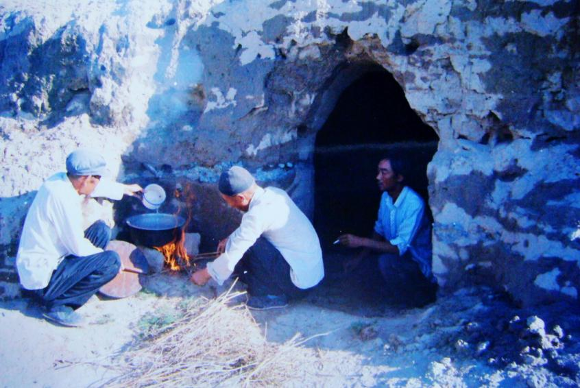 1983年，“六老漢”一代治沙人在“地窩子”生活做飯。新華社發(fā)（八步沙林場供圖）