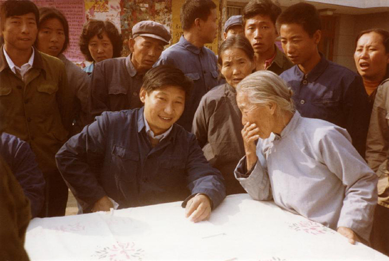 1983年，時(shí)任河北正定縣委書記的習(xí)近平（前排居中），臨時(shí)在大街上擺桌子聽(tīng)取老百姓意見(jiàn)。