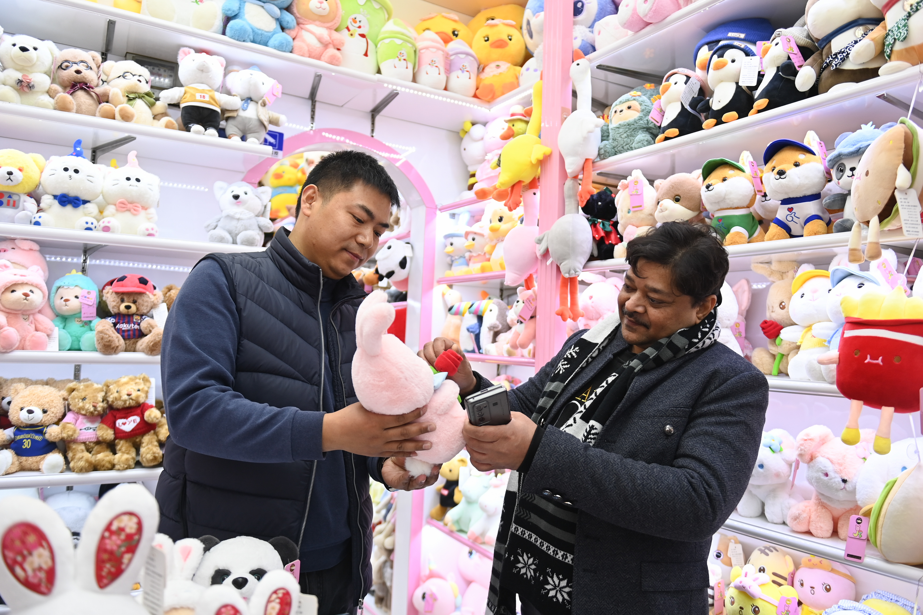 2023年2月2日，來(lái)自印度的客商（右）在義烏國(guó)際商貿(mào)城的一家玩具店鋪內(nèi)選購(gòu)。