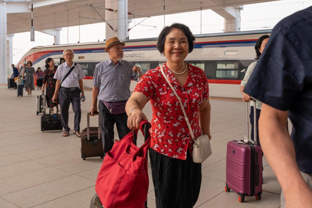 △ 2026年4月13日,乘坐中老铁路国际旅客列车的旅客抵达中老铁路万象站。
