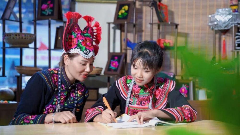 李晓丽指导绣娘学习彝绣图案 图片